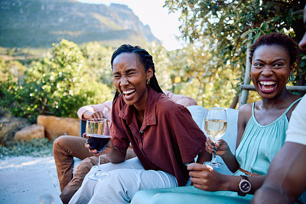 istock Cheerful young women laughing together outdoors with drinks during bright sunny afternoon at scenic vacation destination 2239143585