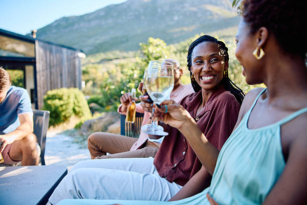 istock Two cheerful friends clinking glasses outdoors during relaxed social gathering at modern vacation rental 2239143594
