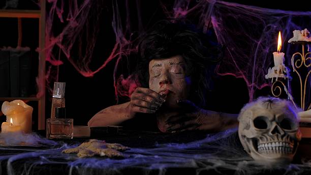 istock Scary zombie hands paint lips with lipstick from a severed dead head 2239151163