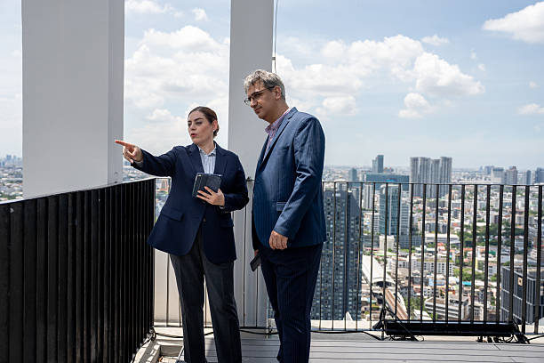 istock Two business people use tablet computer at rooftop office and city background 2239151260