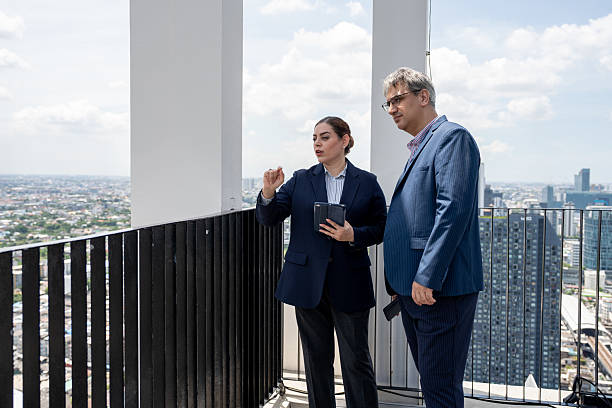 istock Two business people use tablet computer at rooftop office and city background 2239151268