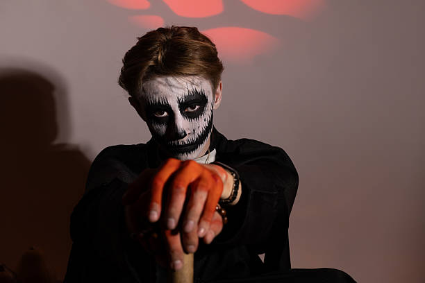 istock Man with a skeleton face holding a knife, staring fiercely 2239151953