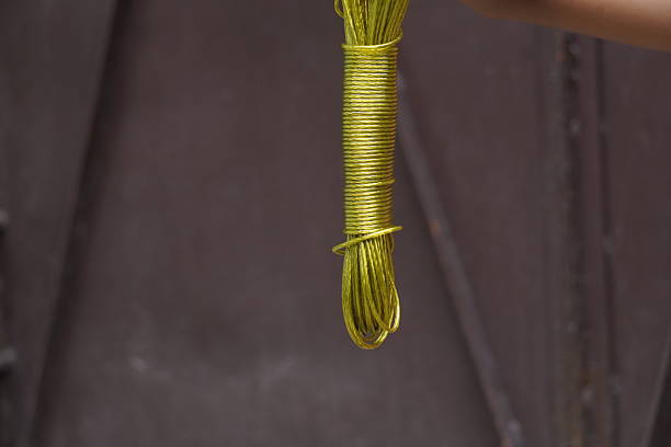 Durable plastic-coated wire rope clothesline, weather-resistant, flexible, anti-rust, strong grip for hanging clothes indoors and outdoors.