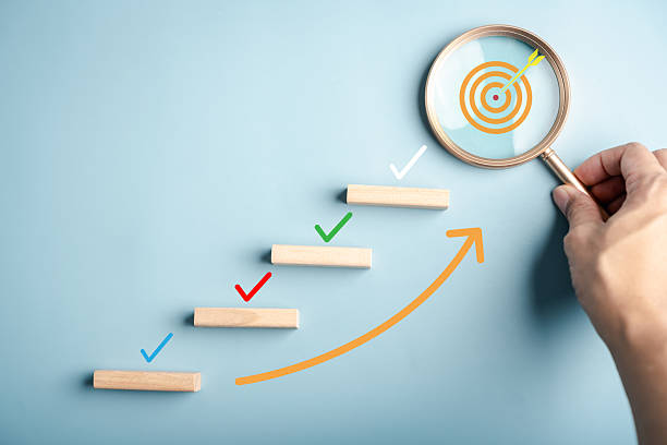 istock Goal setting and growth concept with checklist marks on ascending steps and a target under magnifying glass, representing productivity, planning process, milestone tracking, and achievement. 2239160851