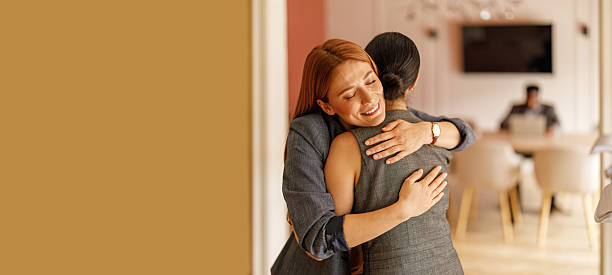 istock Professional woman embracing colleague showing empathy and teamwork while working in corporate office 2239161369
