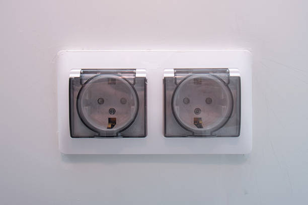 istock Double electric power socket with clear protective cover on a white wall. Home electrical wiring and safety equipment. 2239163837