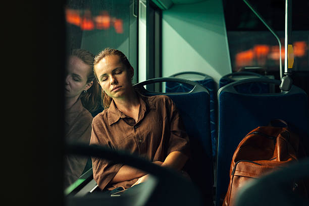 istock Tired urban commuter woman napping on bus at night. 2239164904