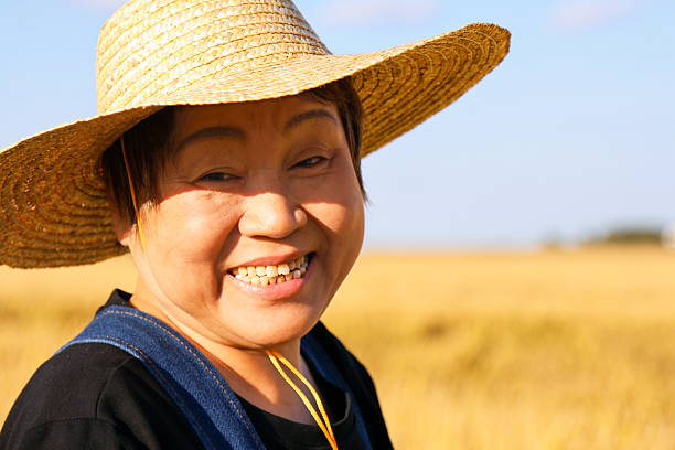 Asian female elder farmer smiling in rice field
