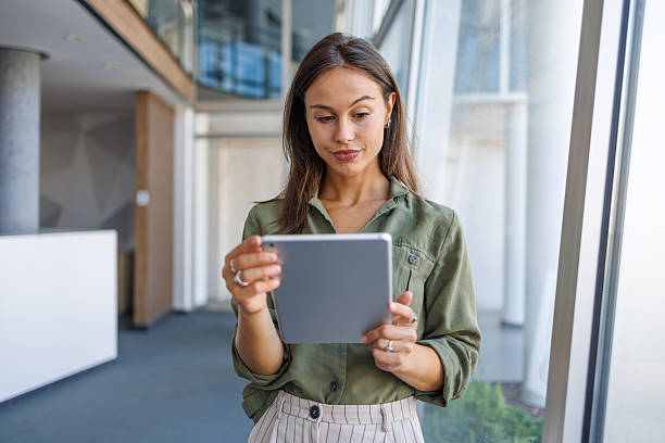 istock Businesswoman using digital tablet standing in modern office 2239165768