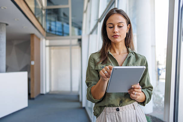 istock Businesswoman using digital tablet in modern office corridor 2239165782