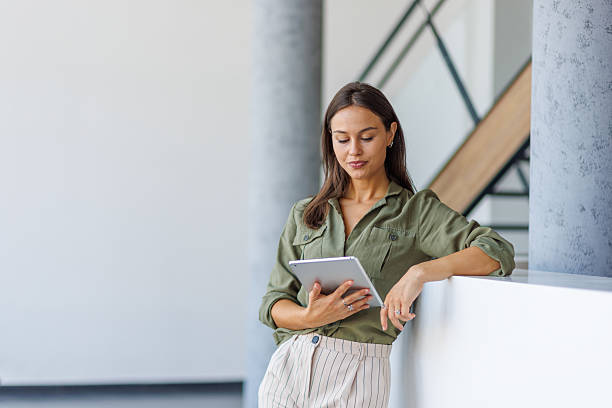 istock Professional woman using digital tablet leaning in modern office 2239165850