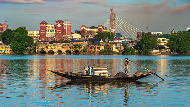 Kolkata , West Bengal, India - August 31 2025:  An Unidentified Fisherman sailing on the River Ganges, overlooking the Famous Howrah Railway Station.