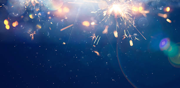 istock Bright sparks light up a dark sky during a festive celebration at snowy winter night. Background 2239169715