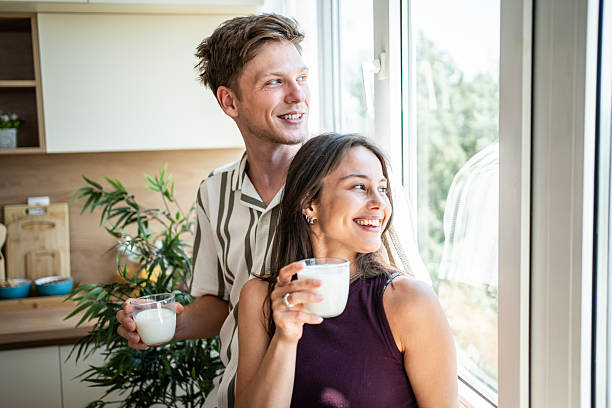 istock Happy young couple drinking milk at home kitchen window 2239171664