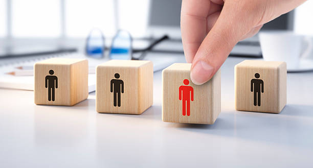 istock Hand placing dice with man symbol on desk between other dices 2239172460