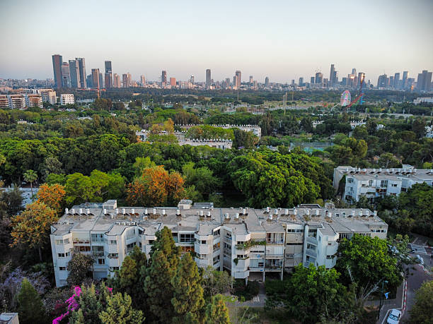 istock Aerial Low rows buildings jut out from between trees -tel aviv 2239183578