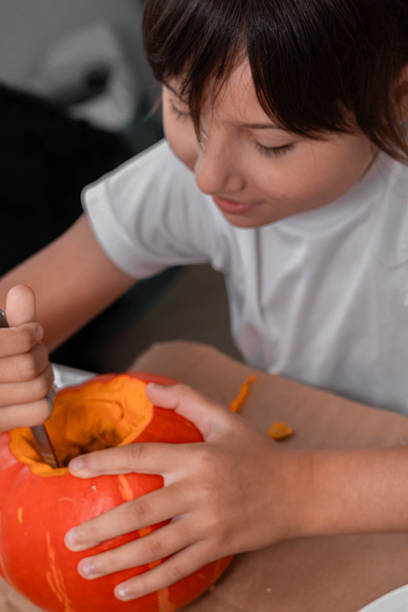 istock Child joyfully carving a pumpkin for Halloween celebration at home 2239190740