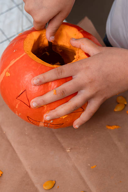 istock Child carving a pumpkin at home 2239190837