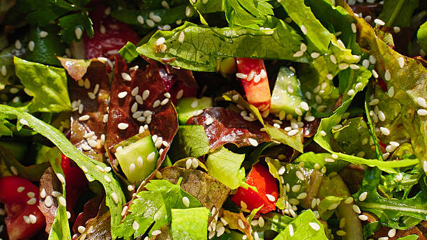 istock Fresh mixed salad with sesame seeds rotating slowly in sunlight, macro close up. 2239191450