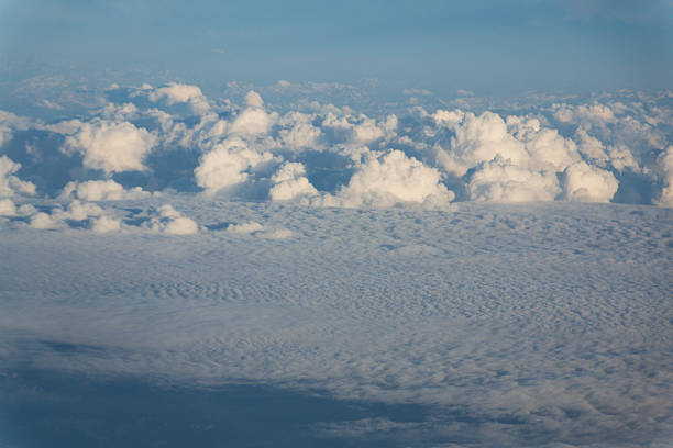 Sky with dramatic beautiful white fluffy clouds viewed from airplane, blue sky, aerial view, copy space, travel concept