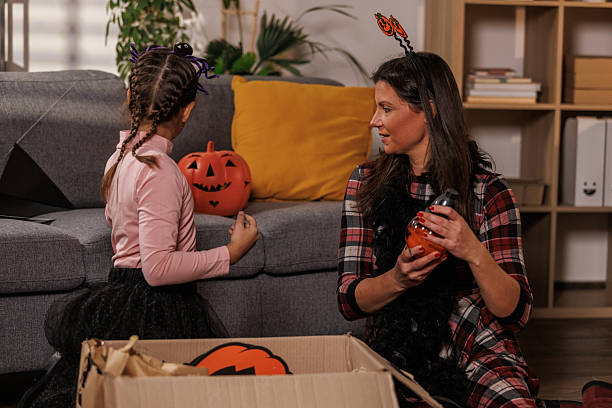 istock Mother and daughter unpacking a box with Halloween decorations 2239192852