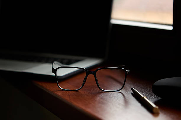 istock Glasses with pen on desk in modern office light 2239195693