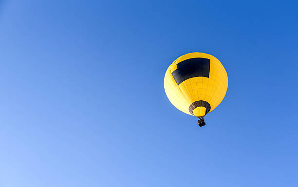 istock Balloons taking off into the blue sky 2239198139