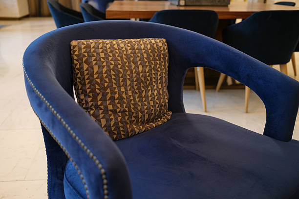 istock A blue chair with a patterned pillow sits in a room Other chairs and a table are visible in the background offering a glimpse into the interior design 2239200524