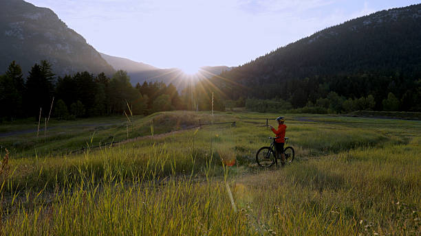 istock Mature man mountain biker uses mobile phone in mountain meadow 2239204670