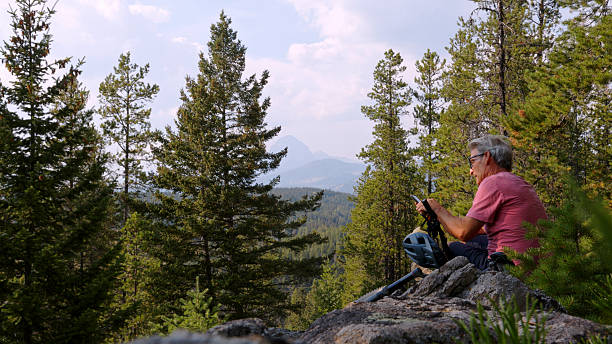 istock Man with e-bike uses mobile phone in forest 2239204830