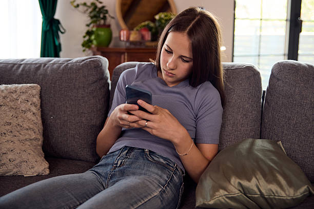 istock Woman relaxing on a sofa at home, using smartphone, casual and cozy mood 2239209141