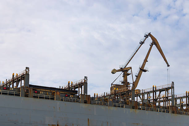 A shipyard in the Hamburg harbor seen from a boat with amazing sky as a background and all the cranes all over the ship.