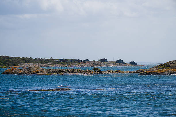 Cabins scattered on rocky coastal island terrain.