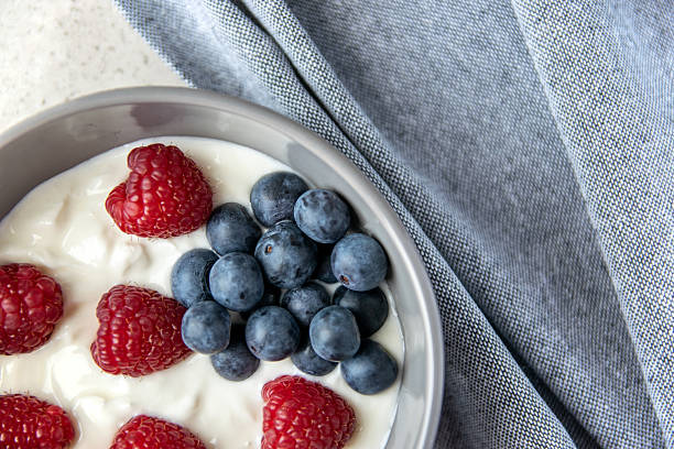 istock Gray ceramic bowl and natural yogurt with blue berries on the stone marble table. 2239216189