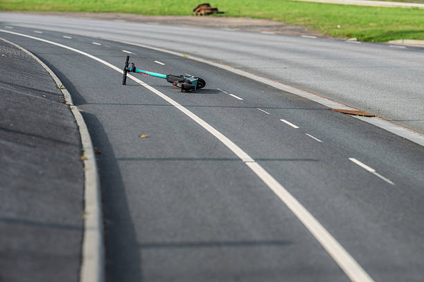 istock Abandoned electric scooter lying on empty road.. 2239216544