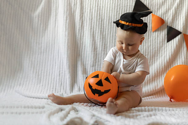istock Cute Child with Halloween Pumpkin in Witch Hat 2239220874