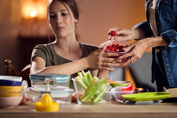 istock Two people share fresh cherry tomatoes at a cozy kitchen table during a home cooking moment 2239222146