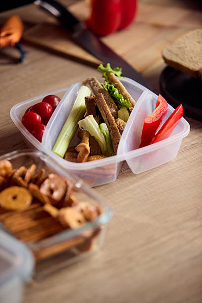 istock Healthy lunchbox with celery, tomatoes, peppers, crackers, lettuce and bread on a wooden table 2239222290