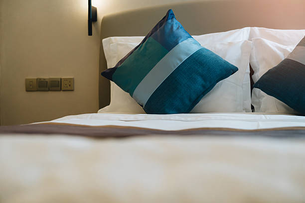 istock pillows in hotel. Cozy Bedroom Setting with Decorative Pillows and Soft Bedding for a Relaxing Atmosphere 2239223991
