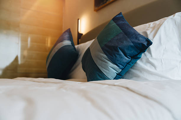 pillows in hotel. Cozy hotel room with modern blue pillows and crisp white bedding featuring soft textures and inviting atmosphere