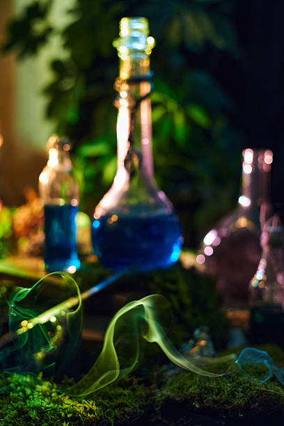 istock captivating scene features various glass flasks filled with colorful liquids, casting vibrant reflections. Wisps of smoke rise, creating a mysterious atmosphere among lush green plants 2239225446