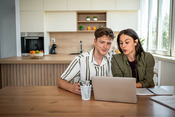 istock Couple planning home finances using laptop in modern kitchen 2239228911