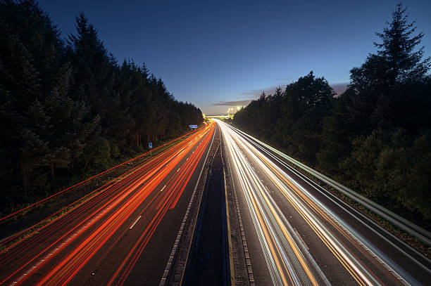 Long exposure photo of highway at night with colorful light trails from cars. Concept of traffic, speed and modern transportation. Scotland