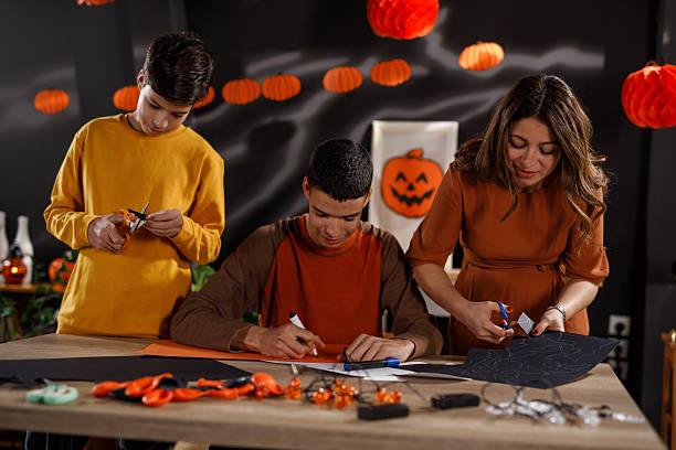 istock Mother and two sons making paper Halloween decorations 2239232219