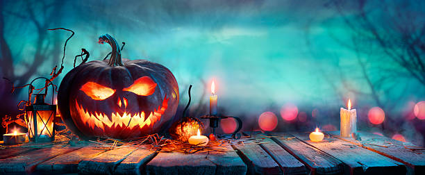 istock Halloween Pumpkins On Table  At Twilight - Jack O’ Lantern In Defocused Forest 2239233180