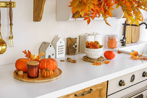 istock Autumn kitchen decor with pumpkins, cutting boards, and vibrant foliage in a bright space 2239233459