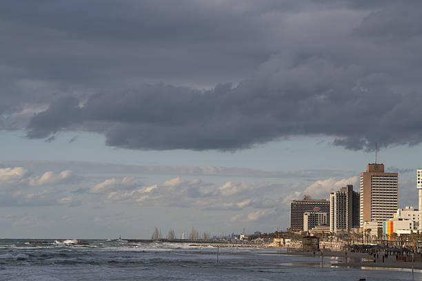 View of Tel Aviv’s modern beachfront skyline with high-rise hotels and the Mediterranean Sea under dramatic clouds, photographed in 2025.