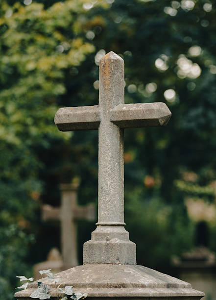 Old Christian cemetery with blurry green nature background.