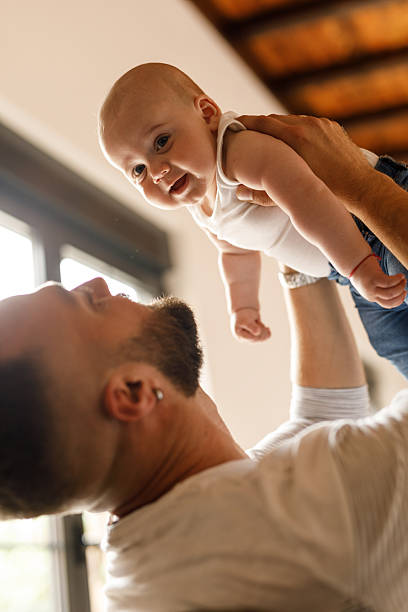 istock Father holding his cute baby boy over his head while playing 2239240867