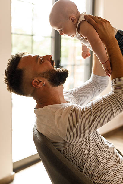 istock Father holding his cute baby boy over his head while playing 2239240868